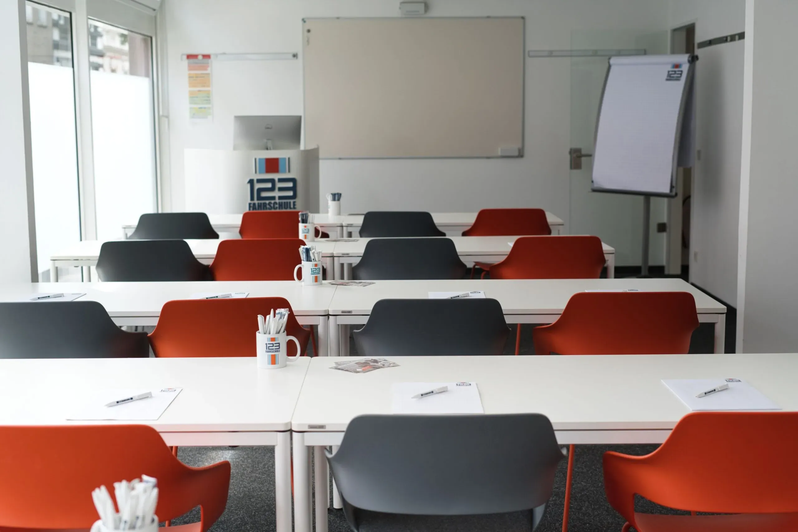 Raum für den Theorieunterricht einer Filiale der 123fahrschule mit Lerntafel und Tischen
